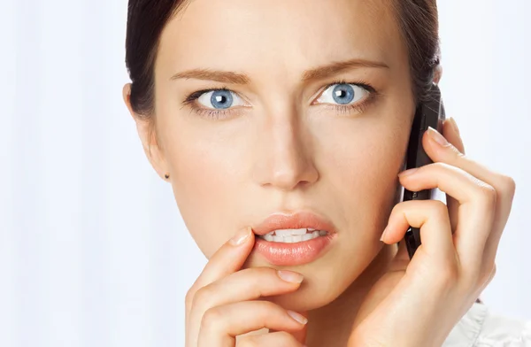 Verwirrte Geschäftsfrau mit Handy im Büro — Stockfoto