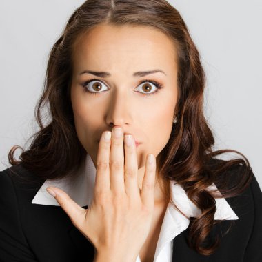 iş kadını elleriyle ağzını, gri kaplama.