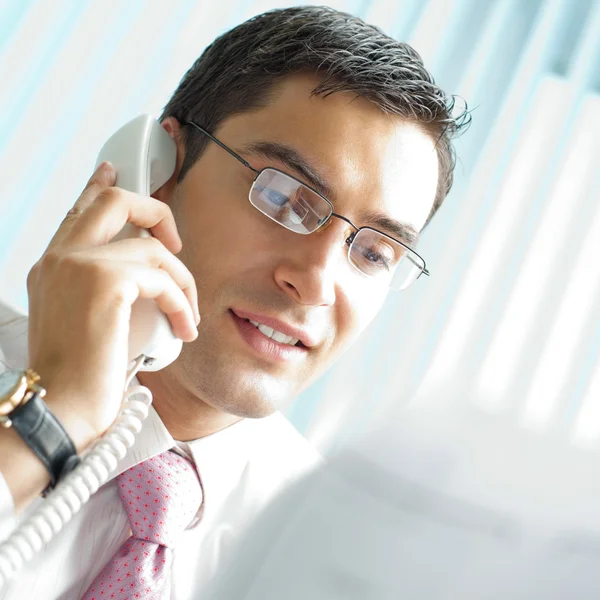 Affärsman med telefon och dokument på kontor — Stockfoto