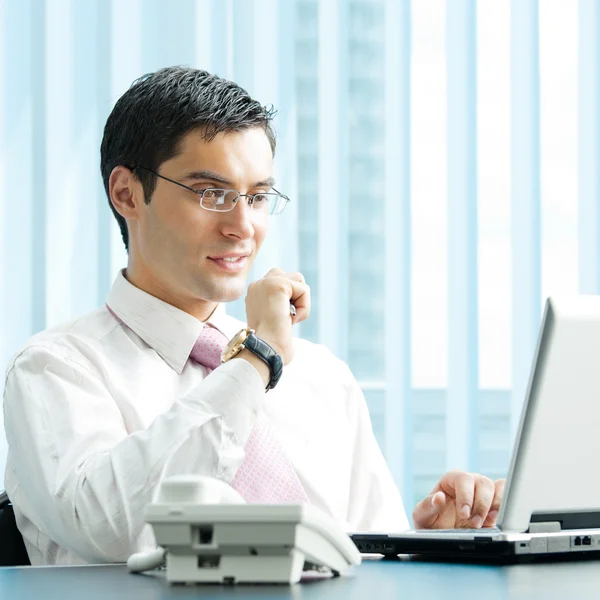 Empresário com laptop no escritório — Fotografia de Stock