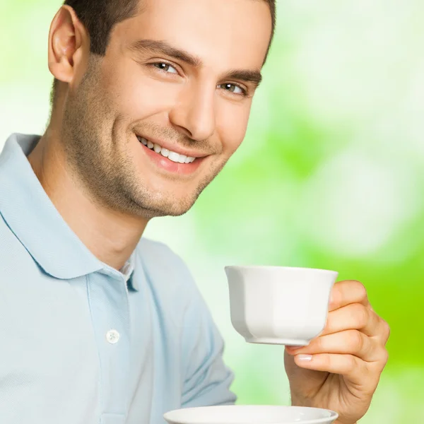 Portret van jonge gelukkig lachende man drinken koffie, buitenshuis — Stockfoto