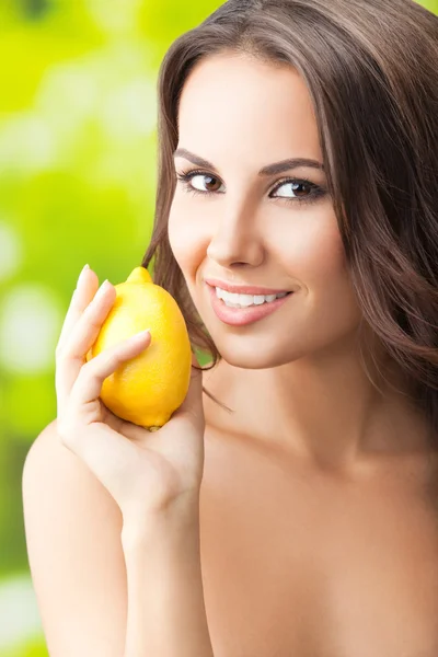 Młody szczęśliwy uśmiechający się kobieta z limon, na zewnątrz — Zdjęcie stockowe