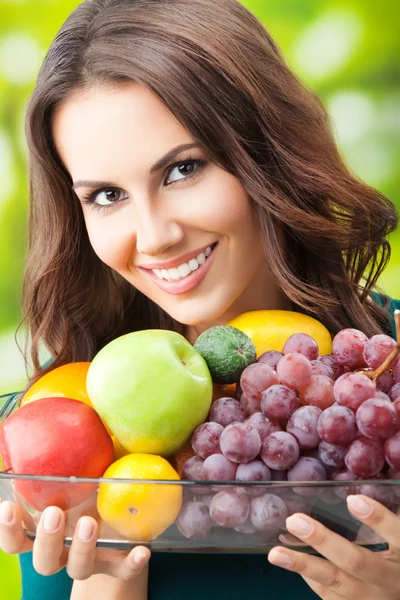 Vrouw met plaat van vruchten, buitenshuis — Stockfoto