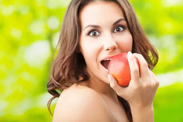 Young woman eating apple, outdoors Stock Image