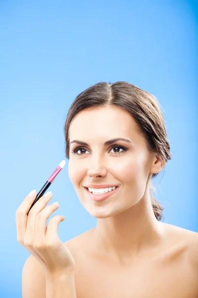 Woman with cosmetics brush, on blue — 스톡 사진