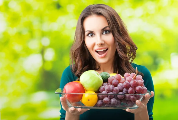 Kvinna med platta med frukter, utomhus — Stockfoto