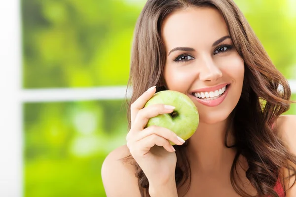 Mujer joven con manzana verde, al aire libre — Foto de Stock