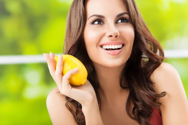 Glücklich lächelnde junge Frau mit Zitrone, im Freien — Stockfoto