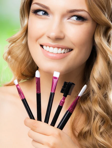 Lachende vrouw met make-up tools, buiten — Stockfoto