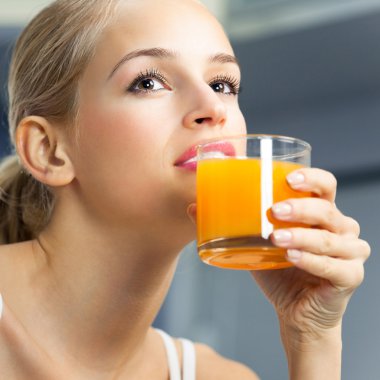 Genç güzel kadın kapalı portakal suyu, içme