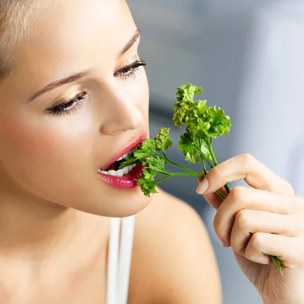 Mulher comendo coentro — Fotografia de Stock