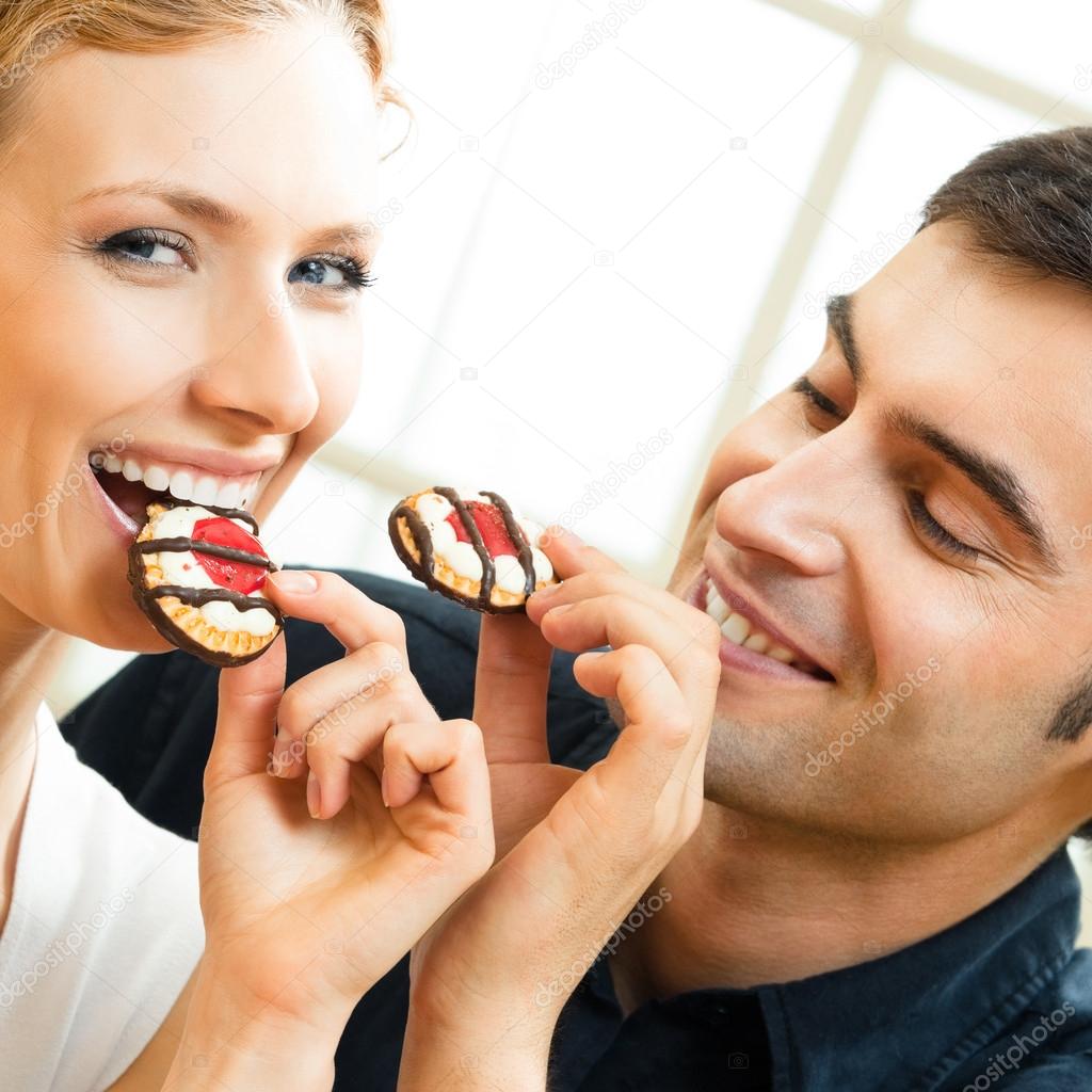 Couple eating cakes — Stock Photo © g_studio 61636075