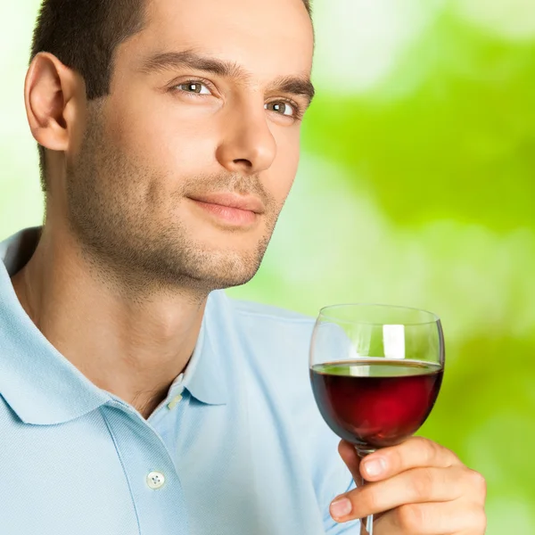 Bel homme avec un verre de vin rouge, en plein air — Photo