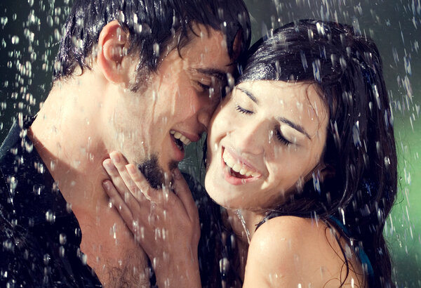 Couple hugging and kissing under a rain, outdoor