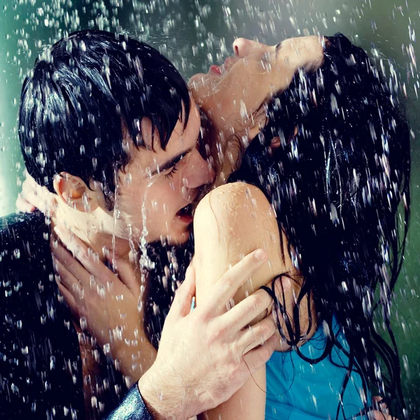 Pareja abrazándose y besándose bajo una lluvia, al aire libre —  Fotos de Stock