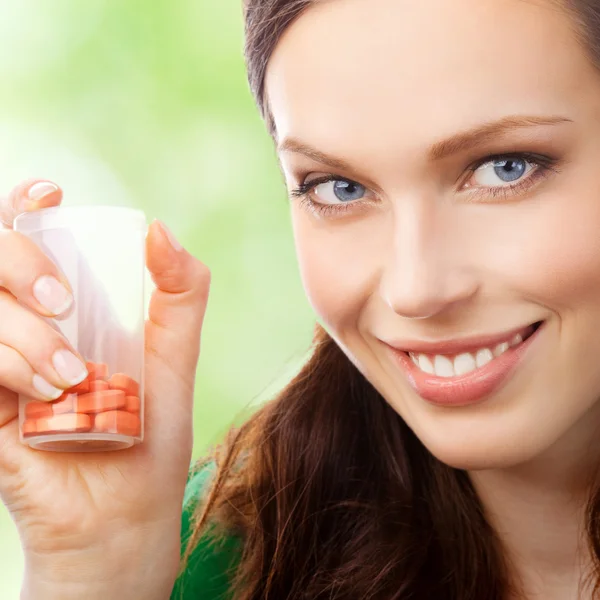 Young woman showing bottle with pills — Stock Photo, Image