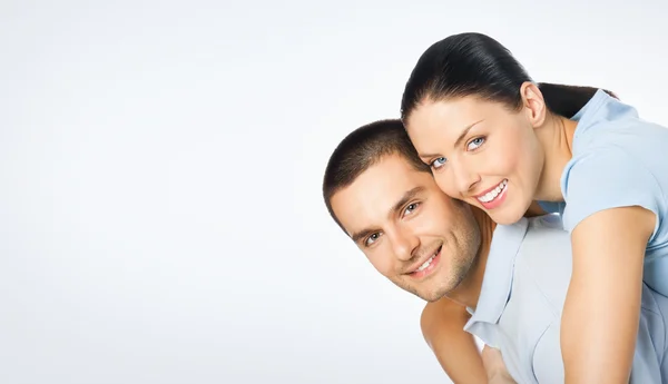 Cheerful amorous young couple, on grey — Stock Photo, Image