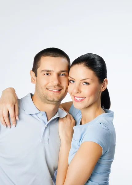 Fröhliches verliebtes junges Paar, auf grau — Stockfoto