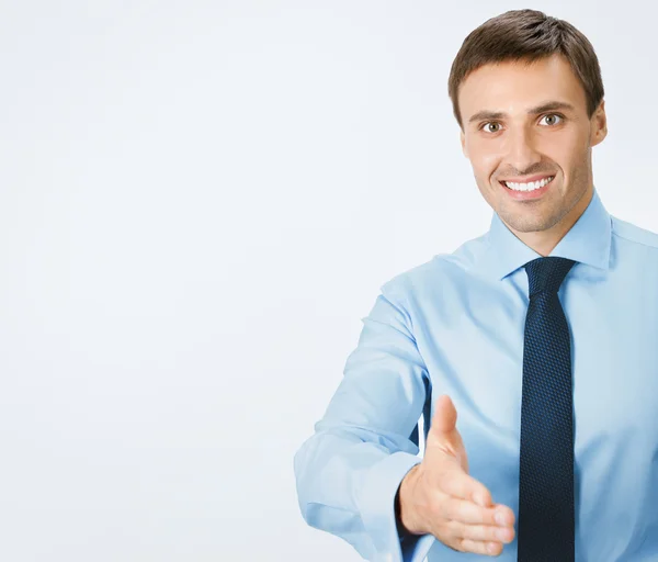 Business man giving hand for handshake, on grey — Stock Photo, Image