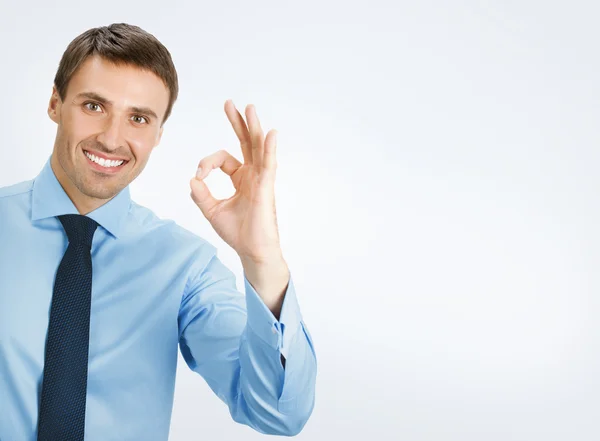 Businessman with okay gesture, on grey — Stock Photo, Image