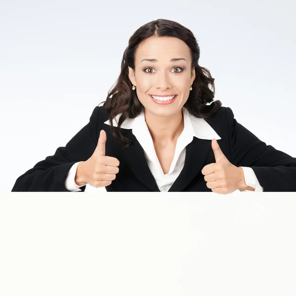 Бізнес-леді, що показує порожню вивіску, над сірим — стокове фото