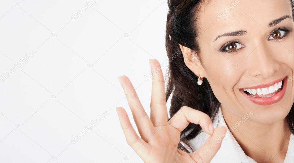 Business woman with okay gesture, on grey