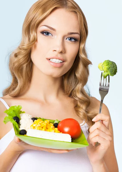 Vrouw met vegetarische salade, over blauw — Stockfoto