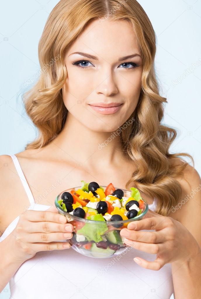 Woman with vegetarian salad, over blue