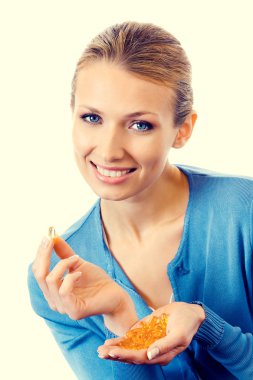 Omega 3 balık ile genç gülümseyen kadın portresi yağ kapsül