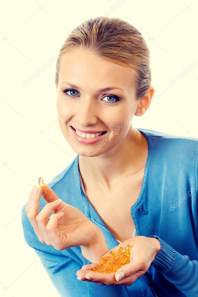 Portrait of young smiling woman with Omega 3 fish oil capsules