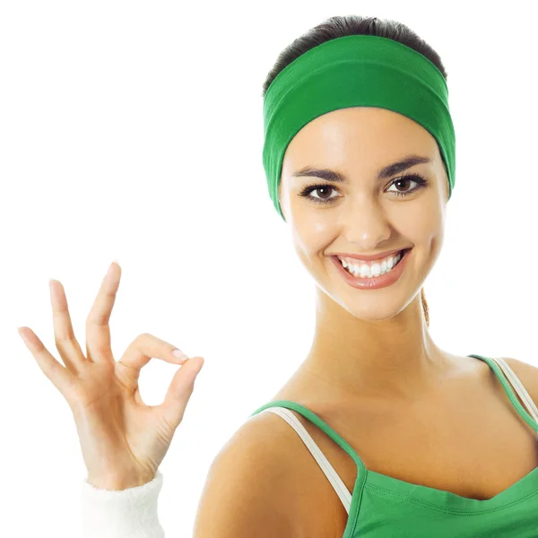 Mujer joven en ropa de fitness verde con signo de aprobación —  Fotos de Stock