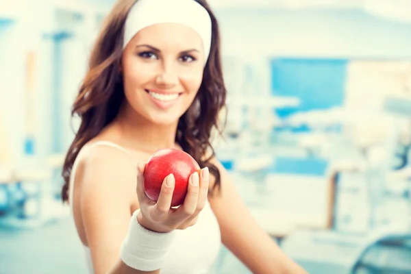 Woman with apple, at fitness gym — Stock Photo, Image