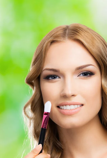 Woman with make up brush, outdoors — Stock Photo, Image