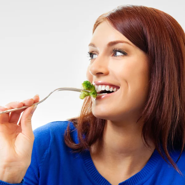 Glad ung vacker kvinna äta broccoli — Stockfoto