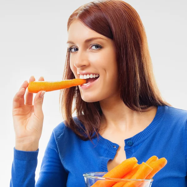 Ung glad kvinna äta morötter — Stockfoto