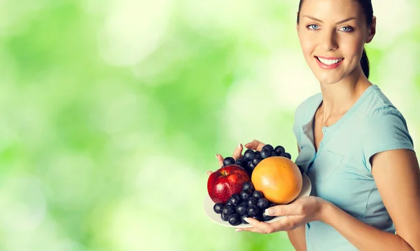 Portrait de belle femme souriante avec assiette de fruits, outdoo — Photo