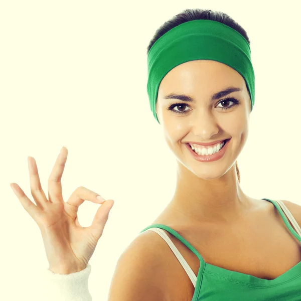 Mujer alegre en ropa de fitness verde con signo de bien —  Fotos de Stock