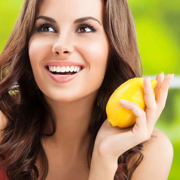 Happy young woman with lemon, outdoors — Stock Photo, Image