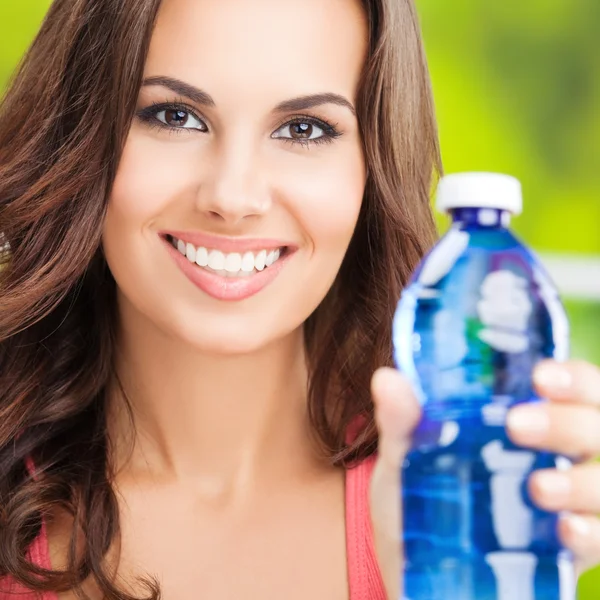 Portret van jonge lachende vrouw met fles water — Stockfoto