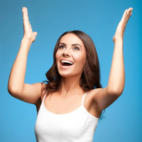 stock image Happy gesturing woman looking up, over blue