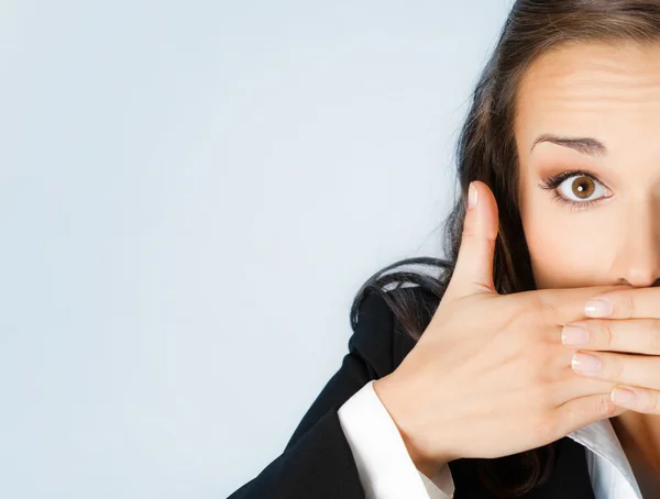 Business woman covering mouth, on blue — Stock Photo, Image