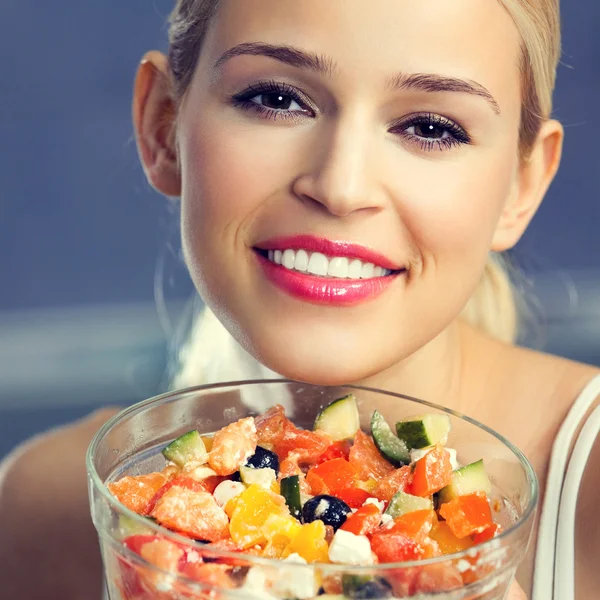 Mujer joven sonriente comiendo ensalada — Foto de Stock