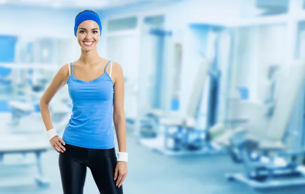 Mujer joven feliz en el gimnasio, con copyspace — Foto de Stock