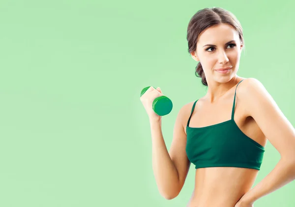 Mulher em desgaste fitness com haltere, em verde — Fotografia de Stock