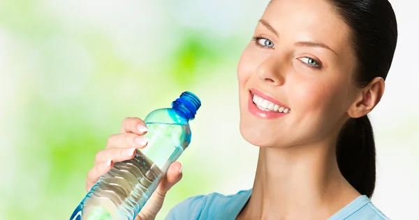 Donna sorridente con bottiglia d'acqua, all'aperto — Foto Stock