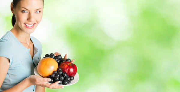 Felice donna sorridente con piatto di frutta — Foto Stock