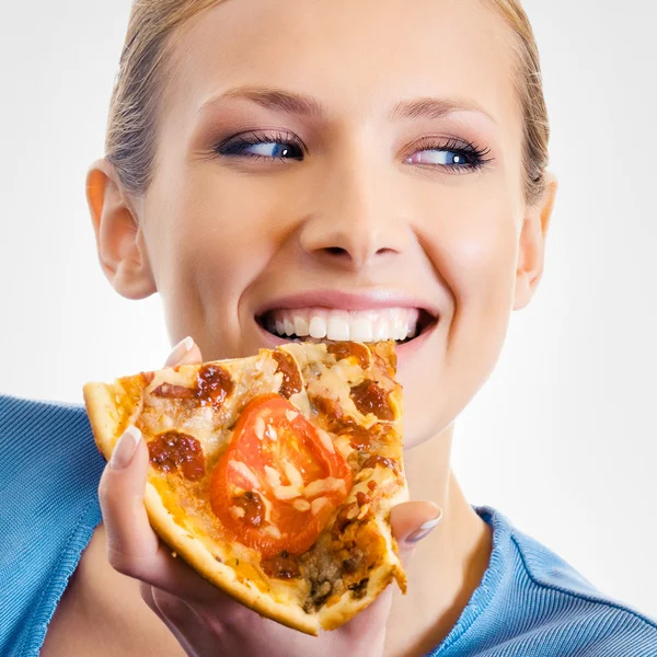 Ung kvinna äta pizza, på grå — Stockfoto