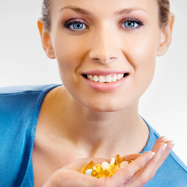Женщина с различными таблетками и капсулами — стоковое фото