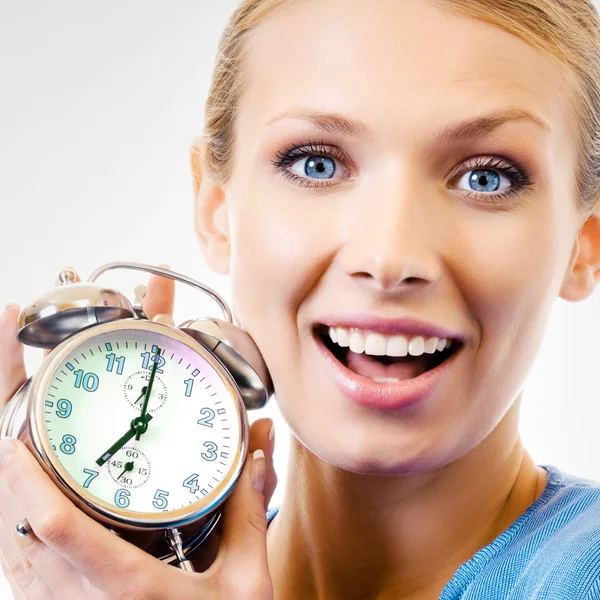 Mujer feliz con despertador, en gris — Foto de Stock