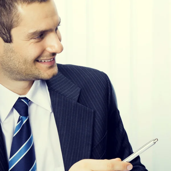 Young businessman giving pen — Stock Photo, Image